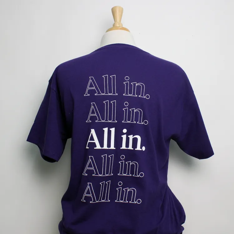 Purple tee shirt with the script "All In" written across the back.