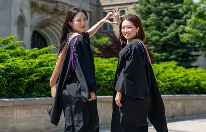 Two students wearing regalia