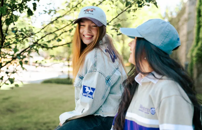 girl in a jean jacket and hat smiling 
